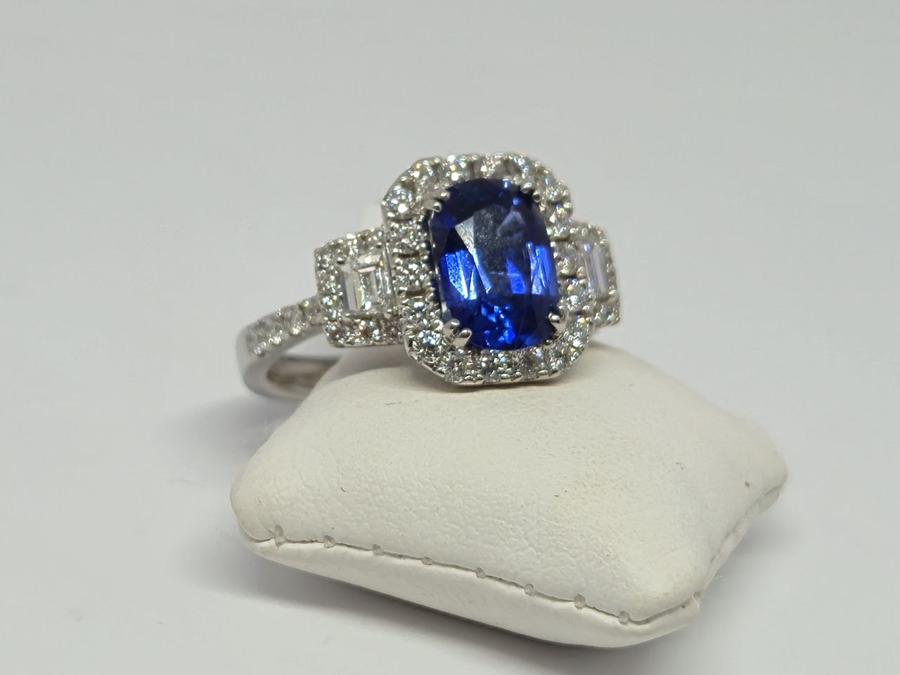 Oval blue sapphire ring with diamond accents in white gold